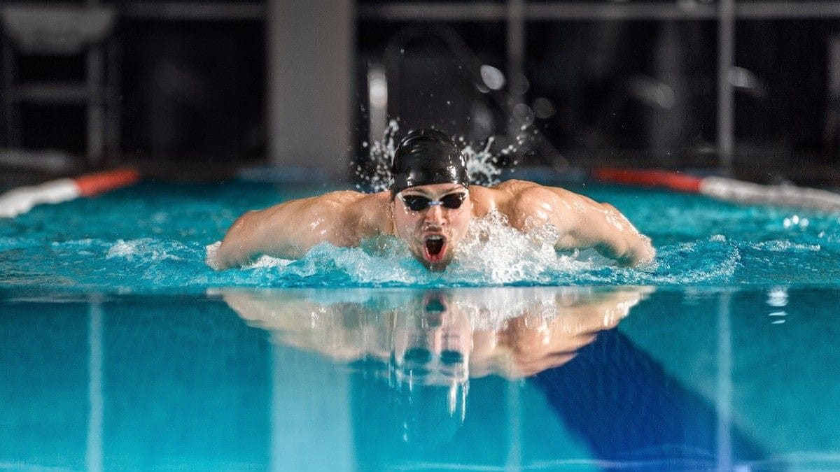 Male swimmer swimming the butterfly stroke to attain swim motivation.