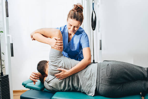 Physical Therapist helps a male for swimmer shoulder